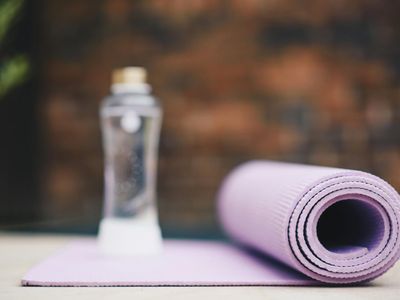Rolled up yoga mat and a bottle of water.